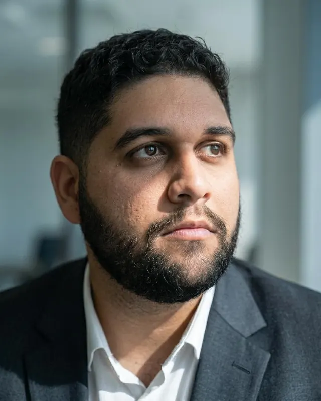 The person behind Linncon Mídia, wearing a dark blazer and white shirt
